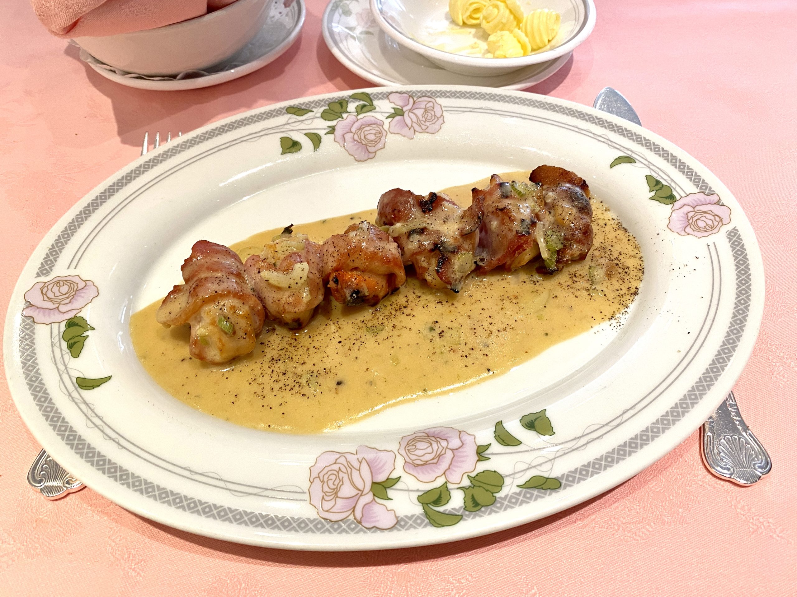 Scallops wrapped in bacon served as a starter at Oslo Court London