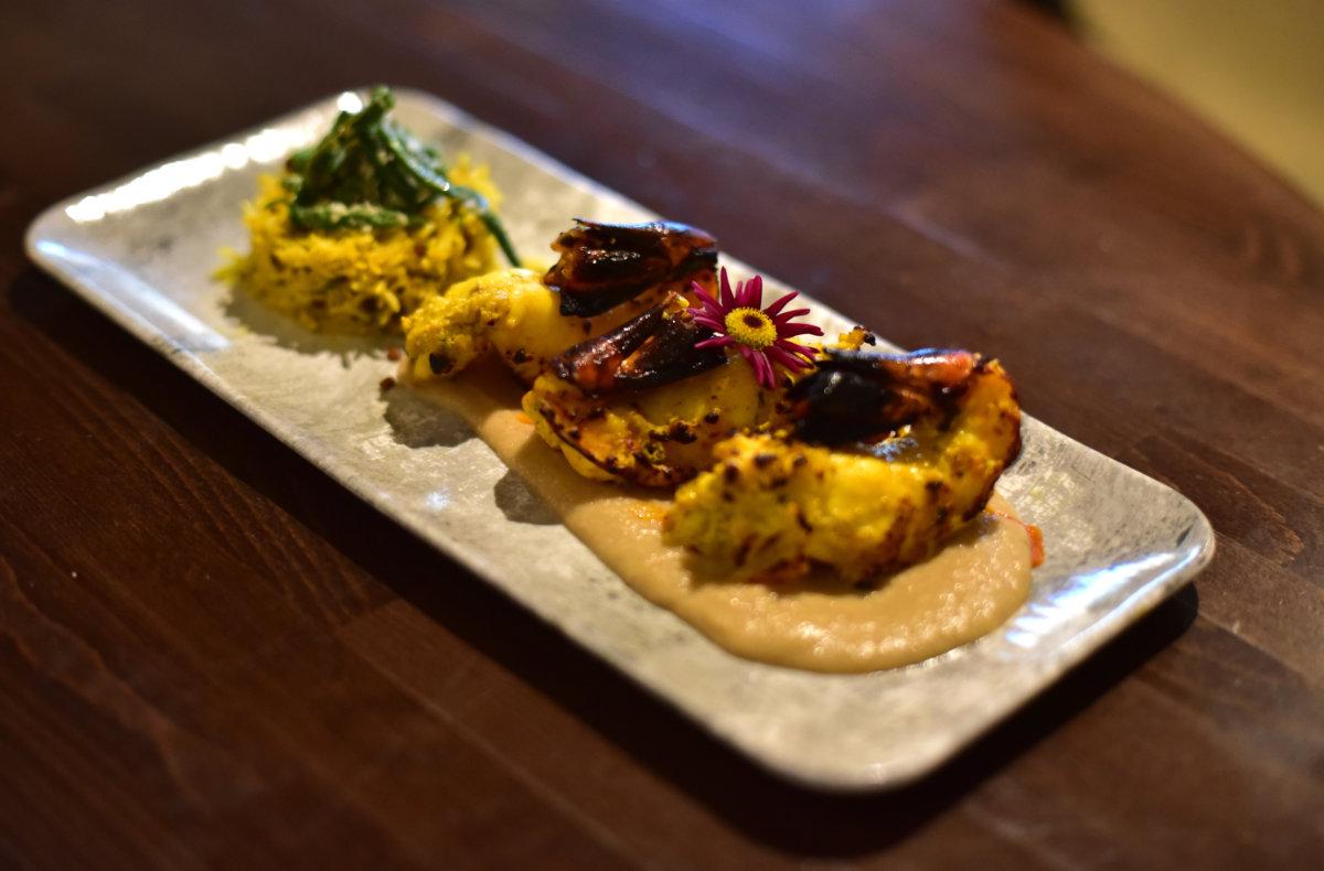 Sarso Ka Jhinga - which is tandoori king prawns marinated with yellow chill powder, kasuni mustard and dill served with korma sauce and fried lemon rice and beans.