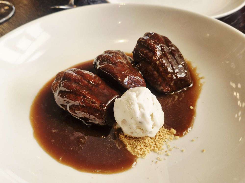 Sticky toffee madeleines are served with vanilla ice cream